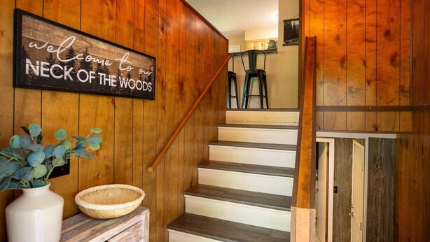 Un escalier en bois sur lequel est accrochée une pancarte indiquant : « Bienvenue dans notre coin de paradis. »