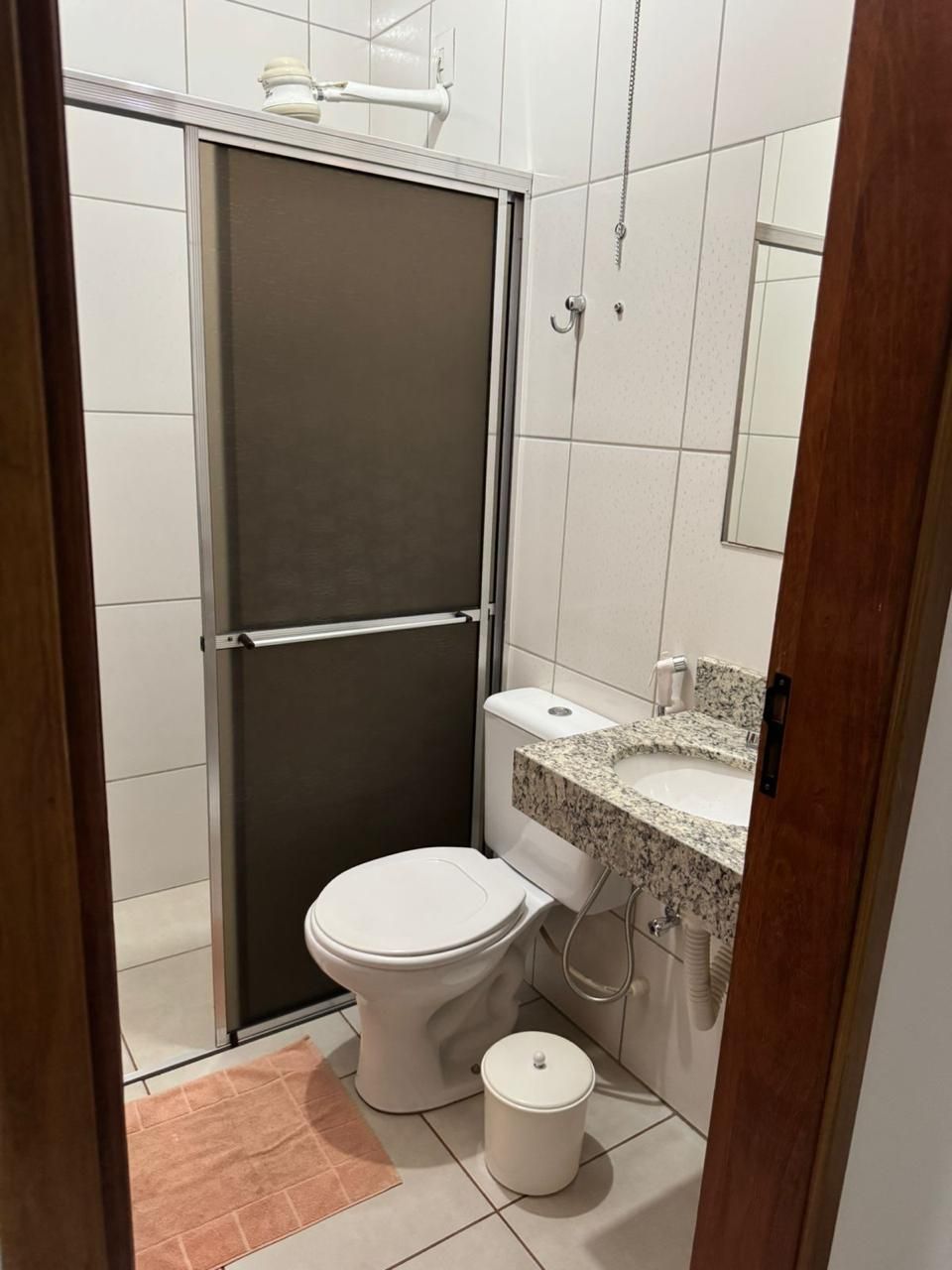 Une petite salle de bain comprenant des toilettes, un lavabo et une cabine de douche.