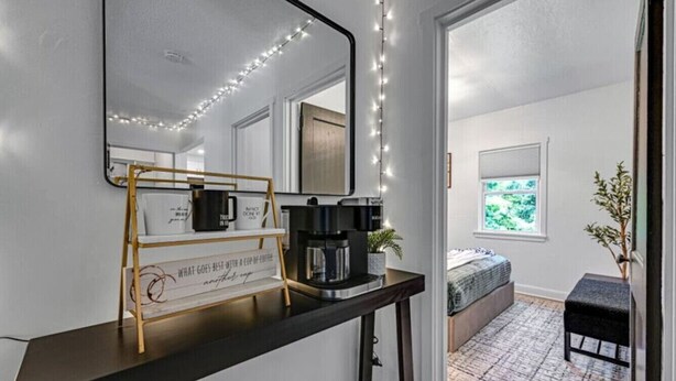 Une salle de bain moderne avec un meuble-lavabo, une machine à café et un panneau sur le comptoir.