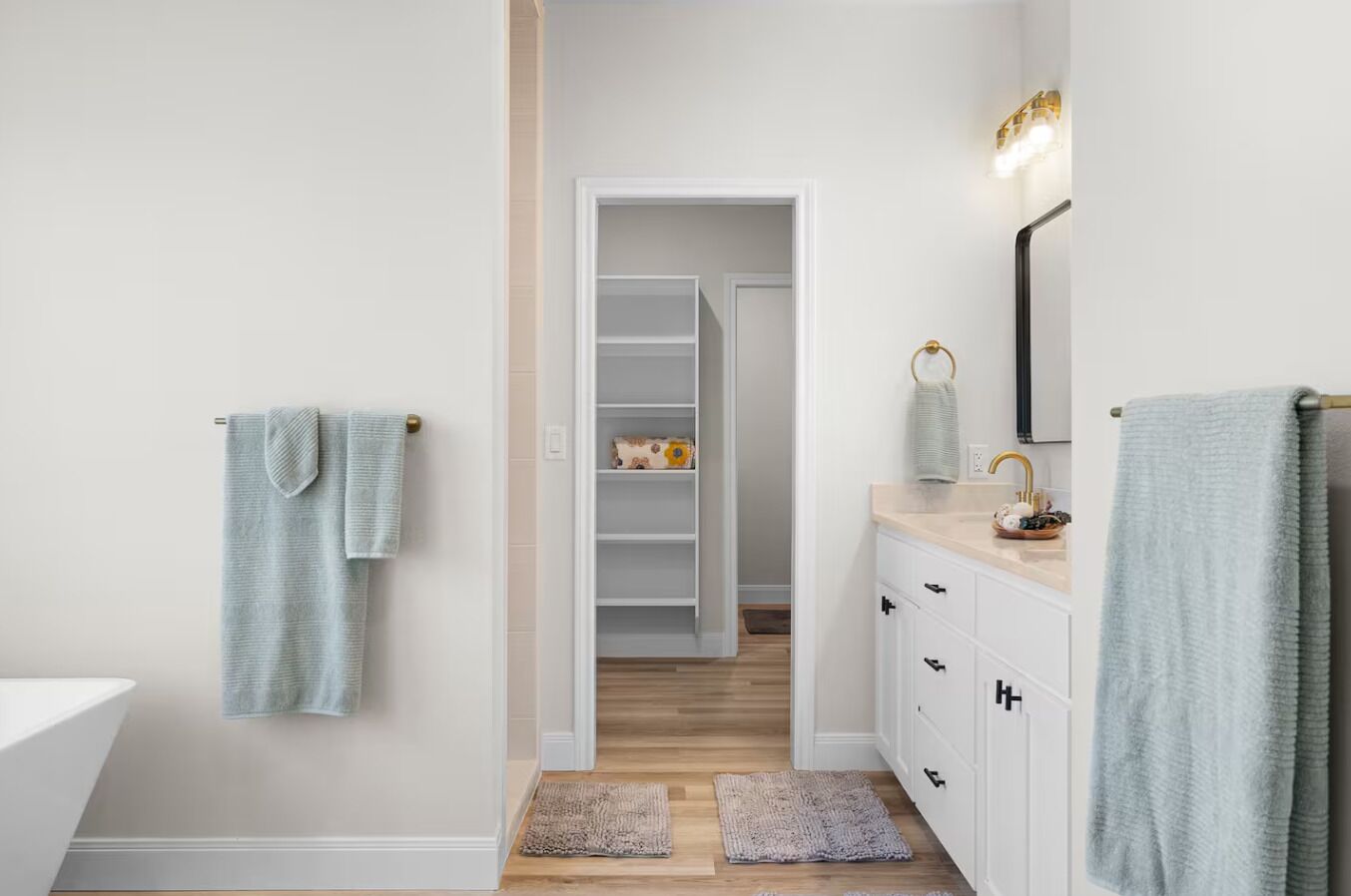A bathroom with a white sink, a mirror, and a towel rack.