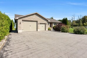 A two-story house with a garage, a driveway, and a well-maintained lawn.