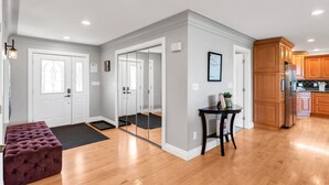 A modern apartment interior with a living room, kitchen, and a hallway leading to a bedroom. - Scenic Waterfront 4BR – Hot Tub/Sleeps 12/Bonfire (Wiarton)