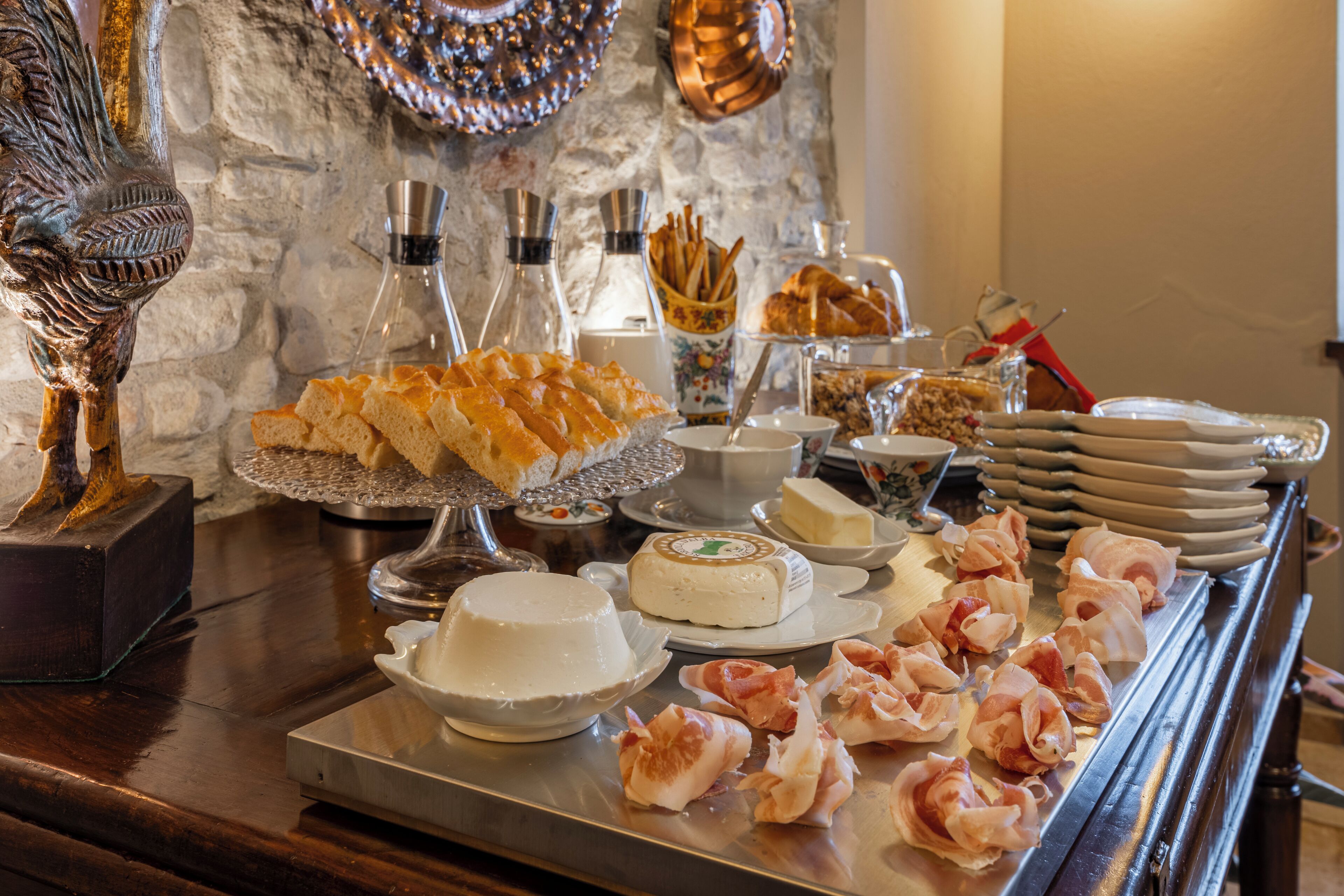 Ein reichhaltiges Buffet mit verschiedenen Speisen, darunter Brot, Käse und Fleisch.