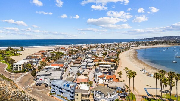 Un pueblo costero con playa, edificios y barcos.
