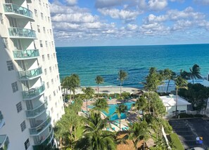 Ein Resort mit Pool, Palmen und Blick auf den Ozean.