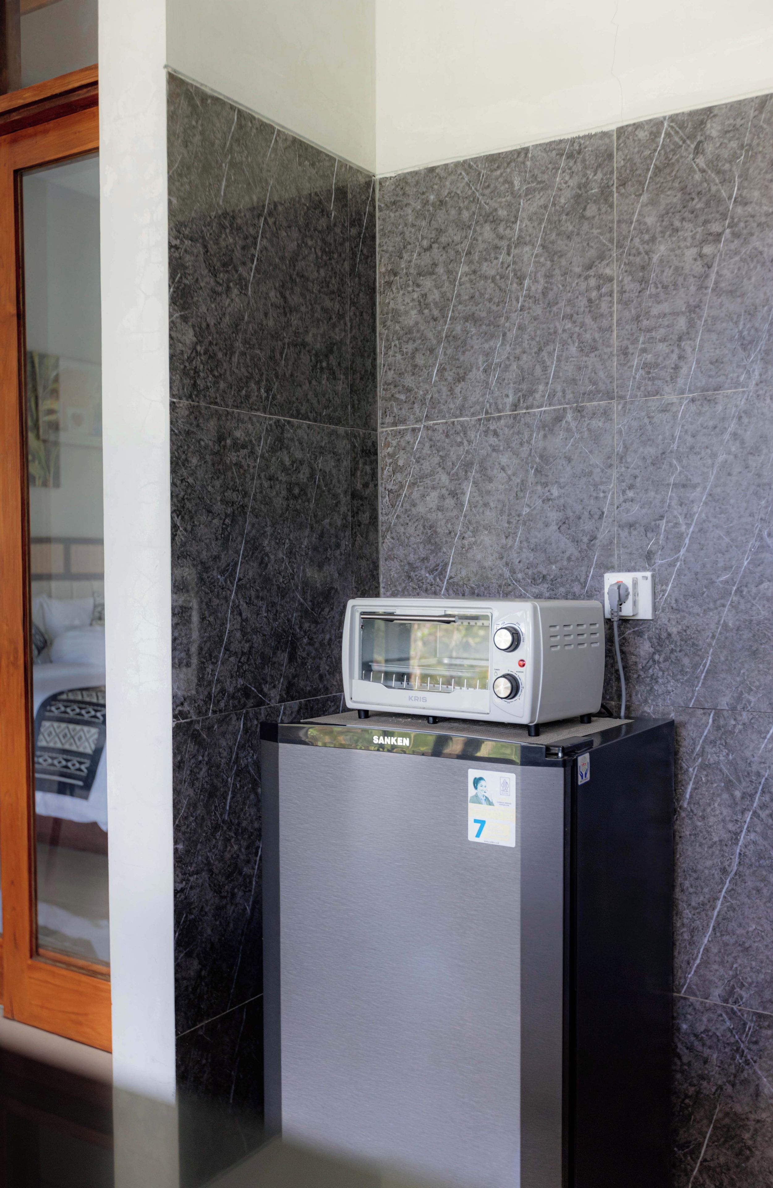 Eine kleine Küchenzeile mit einem Kühlschrank, einem Toaster und einer Mikrowelle.