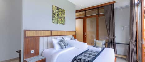 A modern hotel room with a large bed, a wooden headboard, a small bedside table, and a large window with curtains.