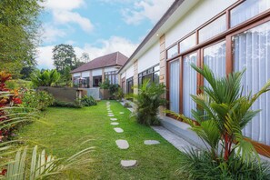 Een modern huis met een verzorgde tuin, een heldere lucht en een duidelijke trap naar de ingang.