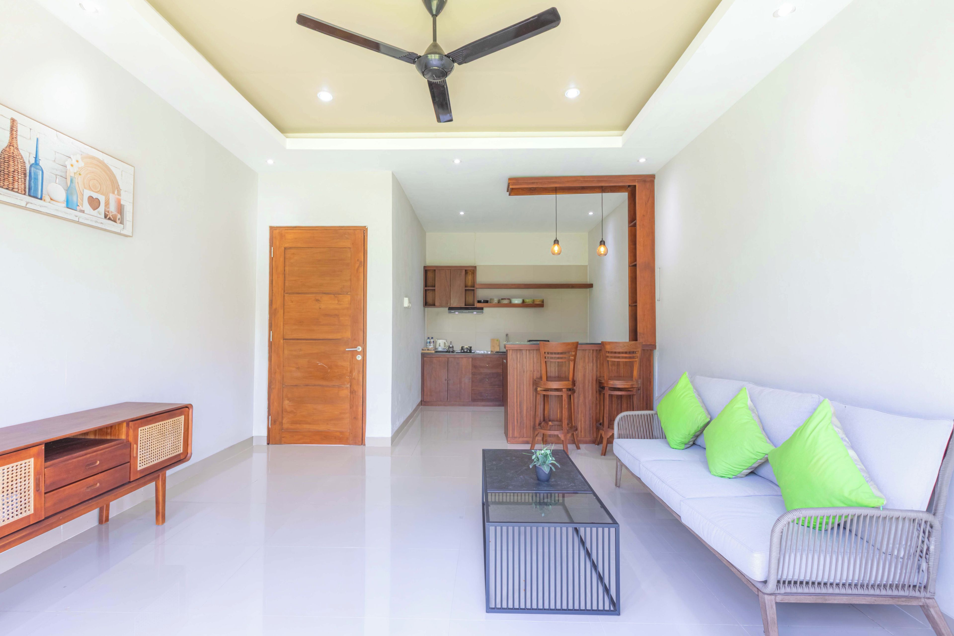 A modern living room with a sofa, coffee table, and a ceiling fan.