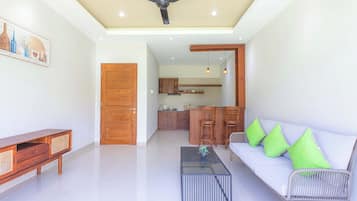 A modern living room with a sofa, coffee table, and a ceiling fan.