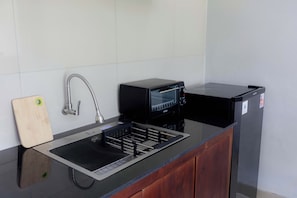 A kitchen with a sink, a toaster, and a small refrigerator. - The green Sidemen  (Klungkung)