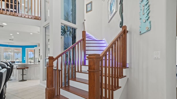 A wooden staircase with a purple-lit landing, leading to a second floor. - Pelican Point Bay on the Water, Boat Slips, View! (Port Isabel)