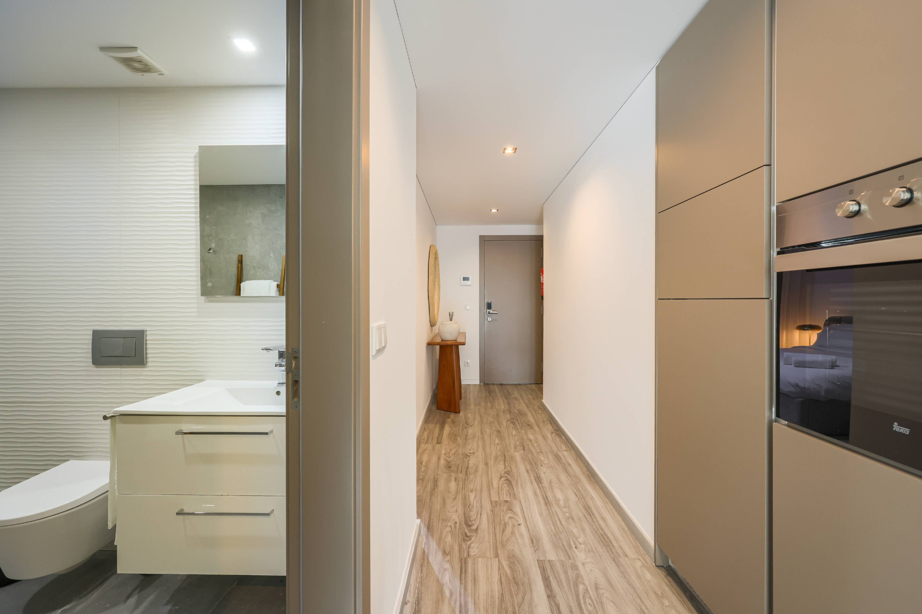 A modern bathroom with a toilet, sink, and mirror.