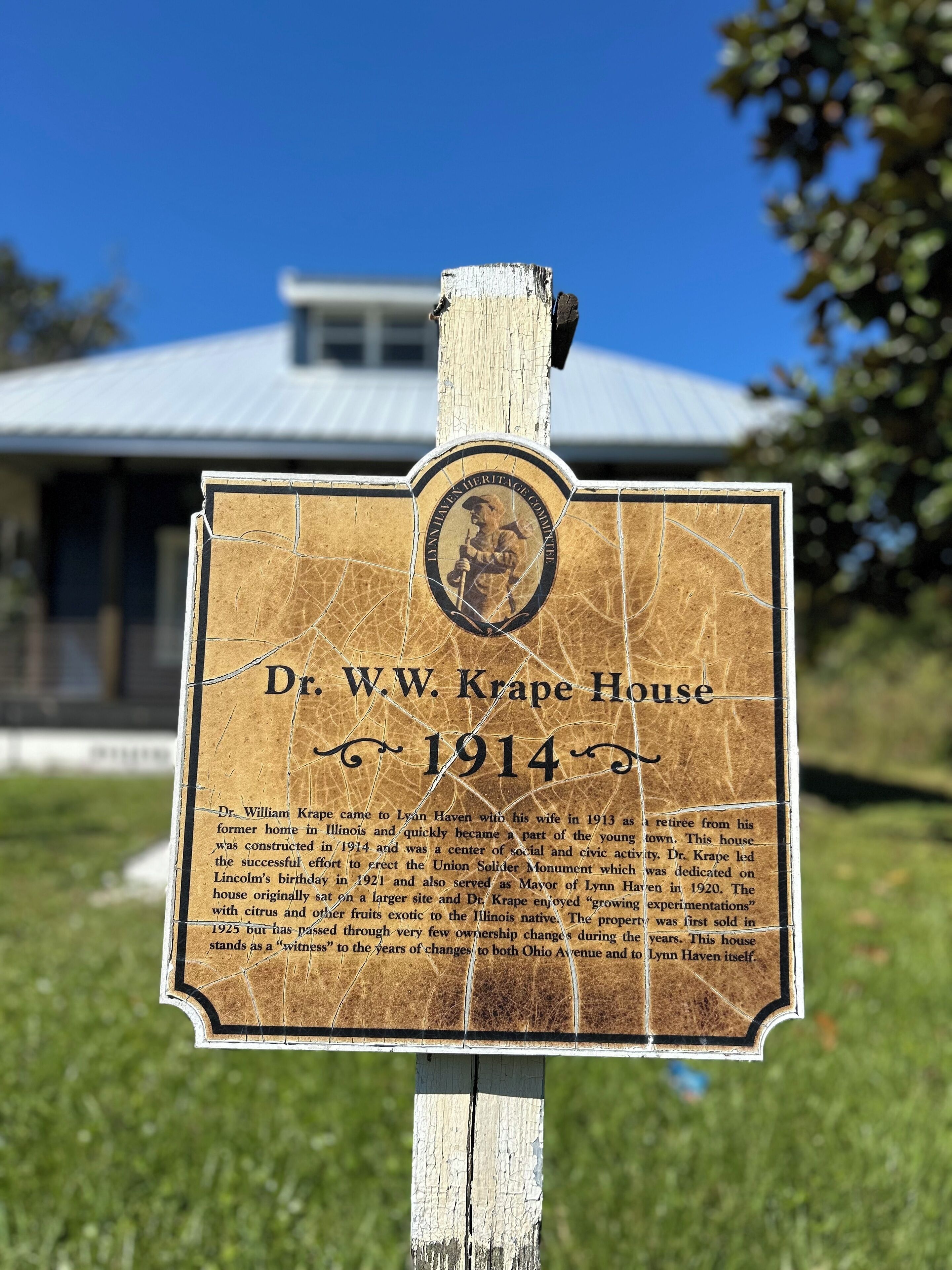 Ein historisches Hinweisschild zum Dr. W.W. Krape House, gegründet 1914, mit Informationen über seine Bedeutung und Geschichte.