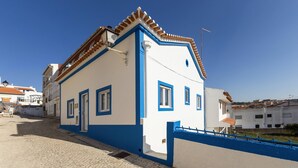 Un bâtiment blanc avec des bordures bleues et un toit recouvert de tuiles.