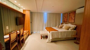 Une chambre à coucher avec un lit, une table de chevet, une chaise et un téléviseur fixé à un mur en bois.