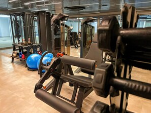 A gym with exercise equipment, including a treadmill, weight machines, and exercise balls. - Aquamaris Luxo - by Almare (João Pessoa)