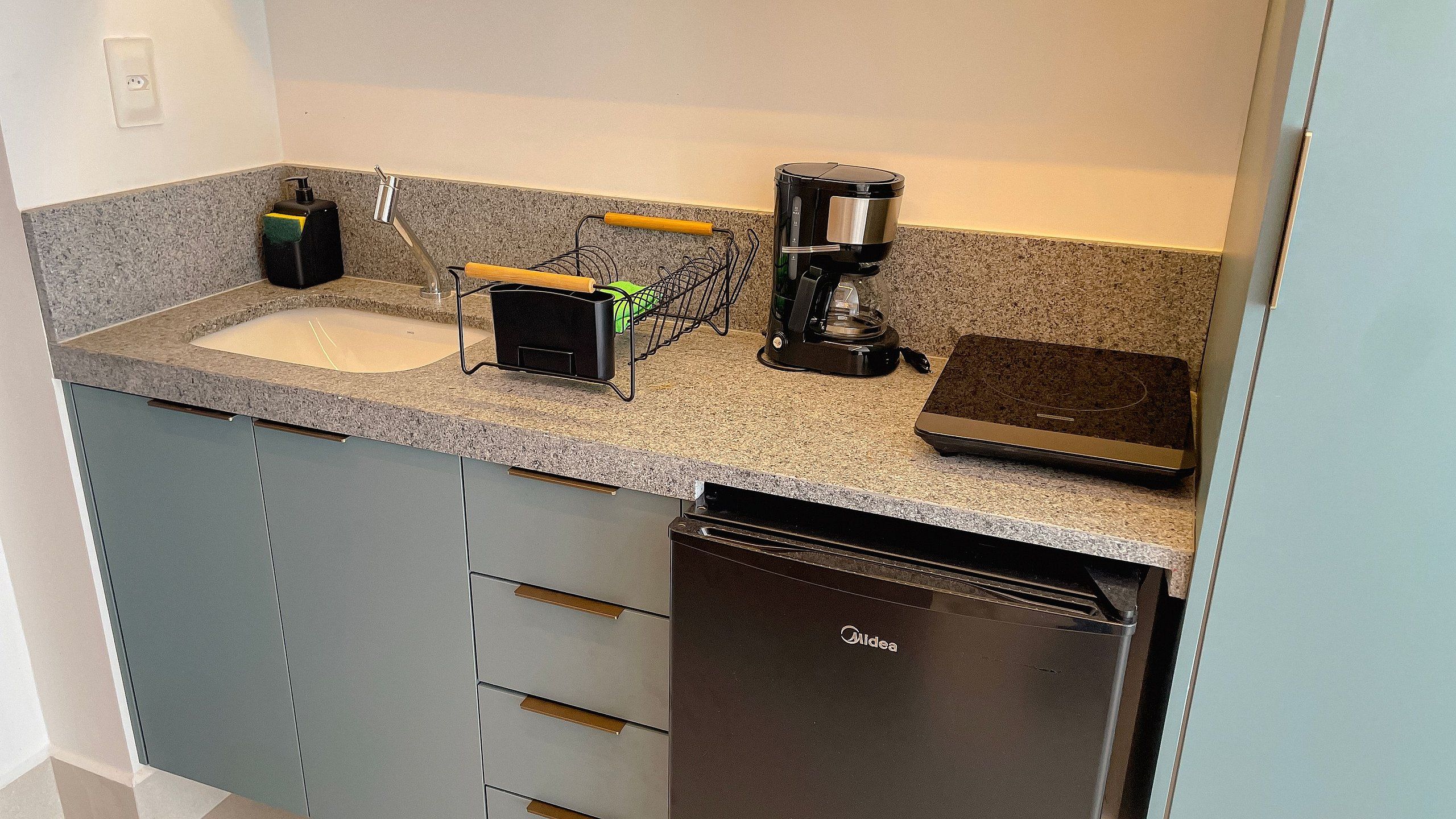 A kitchen with a dishwasher, a coffee maker, and a sink.