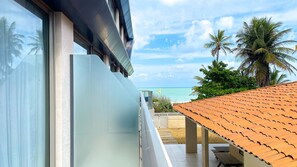 A modern building with large windows, a balcony, and a view of the ocean. - Aquamaris Luxo - by Almare (João Pessoa)