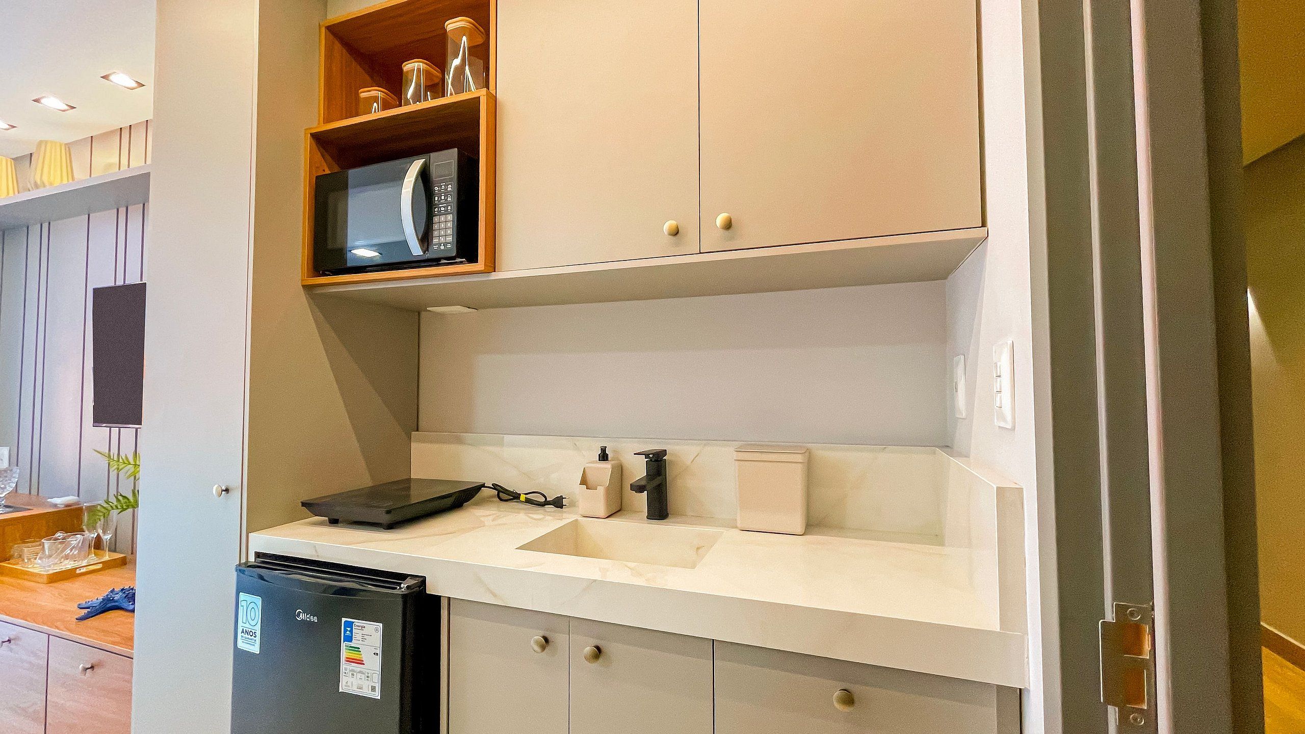 Una cocina moderna equipada con microondas integrado, fregadero y lavavajillas.