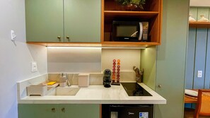 Una cucina dotata di forno a microonde integrato, lavello e lavastoviglie.