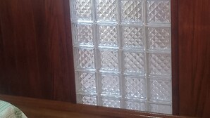 Ein Zimmer mit Holzwänden und einer großen Glastür mit Rautenmuster.