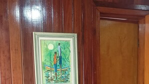 Ein Zimmer mit Holzwänden, einem gerahmten Gemälde und einer Tür.