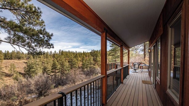 A wooden deck with a railing overlooking a forested area. - Private Pagosa Springs Retreat with Views, Hot Tub and Game Room (Pagosa Springs)