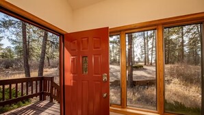 A wooden deck leading to a red door with a window, overlooking a forested area. - Private Pagosa Springs Retreat with Views, Hot Tub and Game Room (Pagosa Springs)
