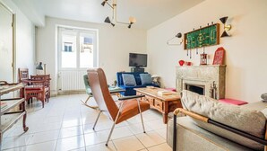 A living room with a television, sofa, and fireplace.