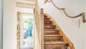 A wooden staircase with a handrail, leading to a door.