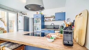 A modern kitchen with blue cabinets, a wooden countertop, and a built-in oven.