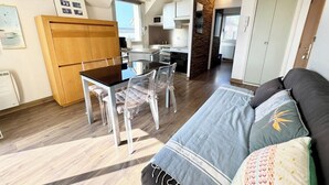 A compact living space with a dining area, kitchenette, and a bed. - Appartement idéal face mer – Tout à pied (Ploemeur)