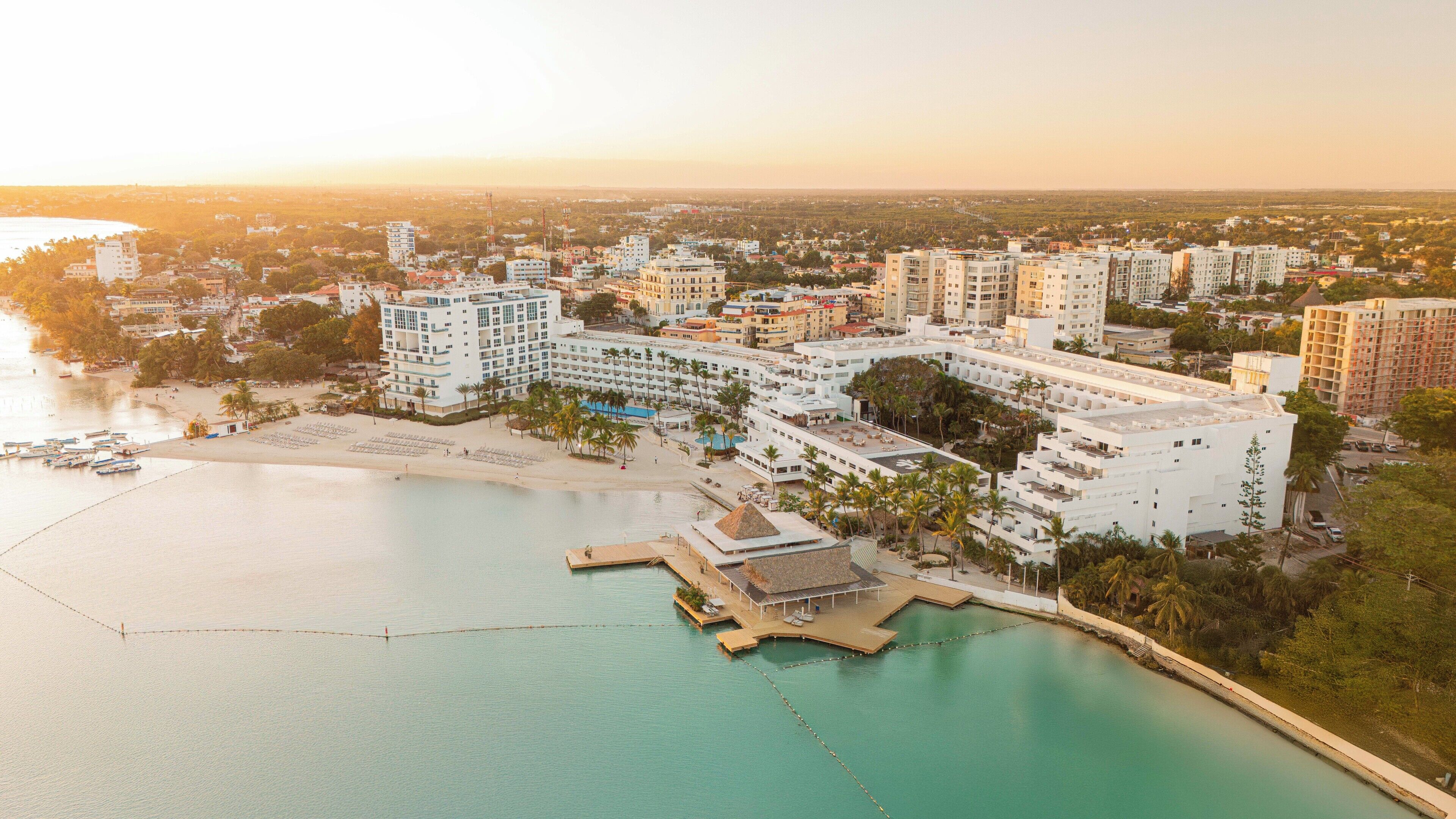 Un hôtel situé sur la côte, composé de plusieurs bâtiments, avec une plage et un port de plaisance.