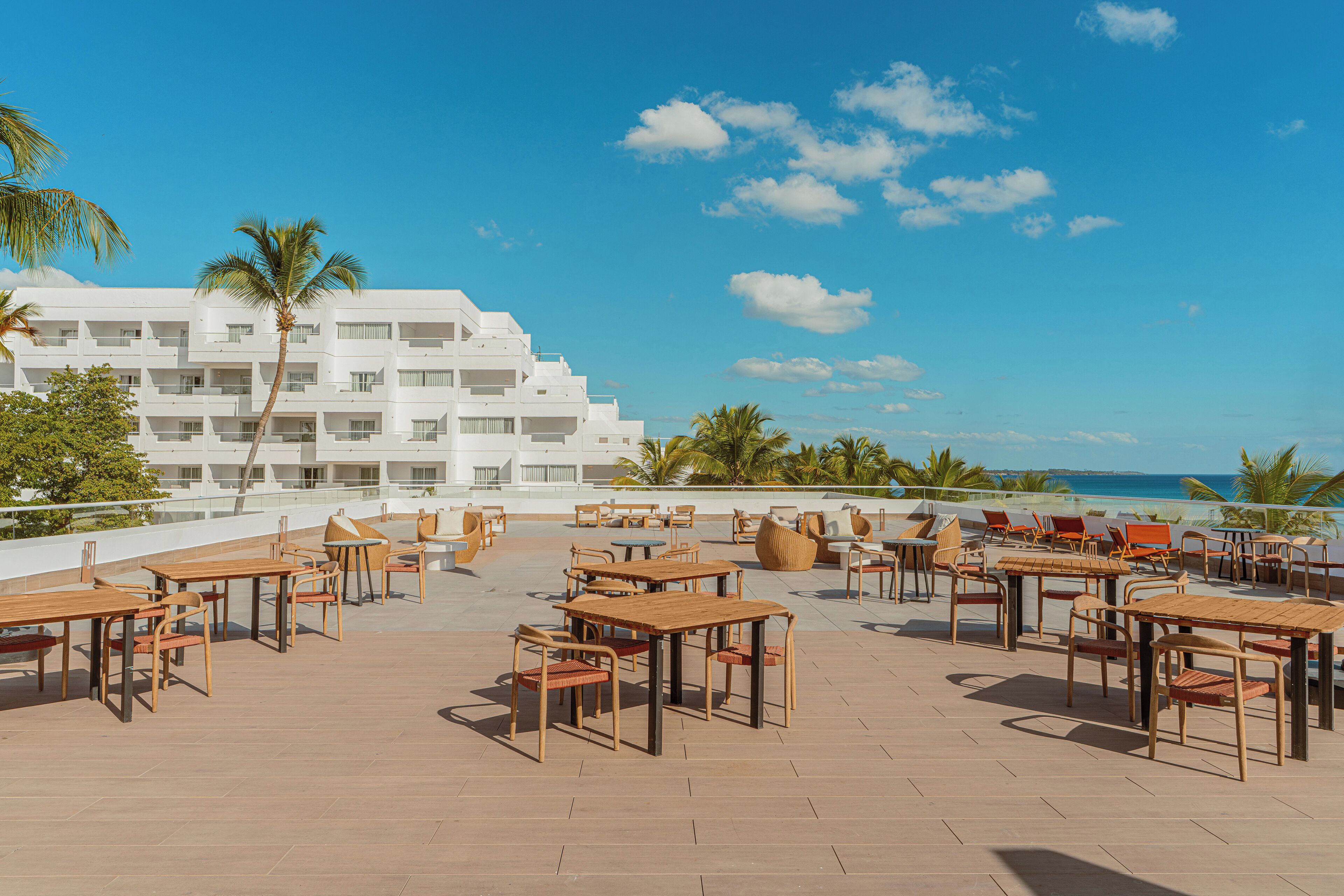 A rooftop terrace with outdoor seating and a view of the ocean.