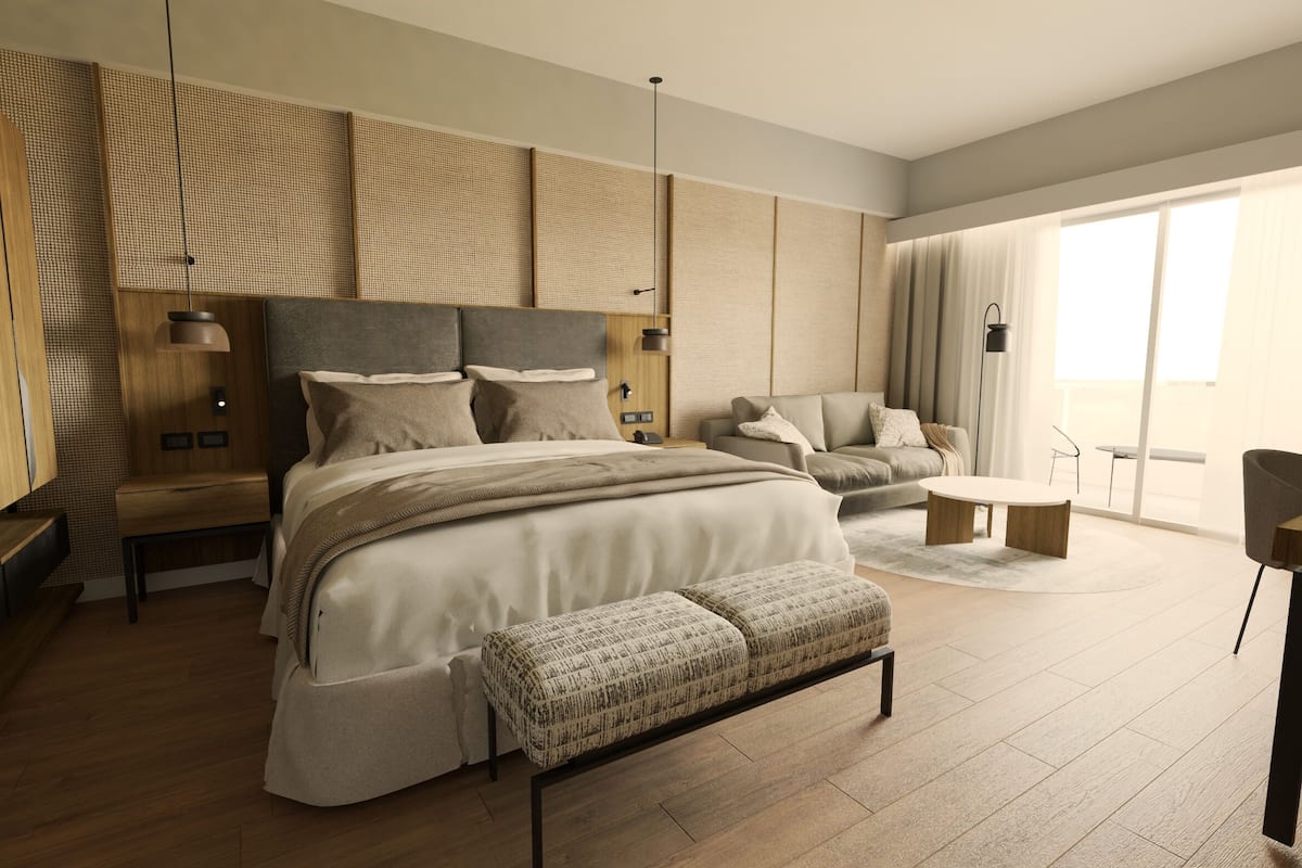 Um quarto moderno com uma cama grande, um sofá, uma pequena mesa e um banco.