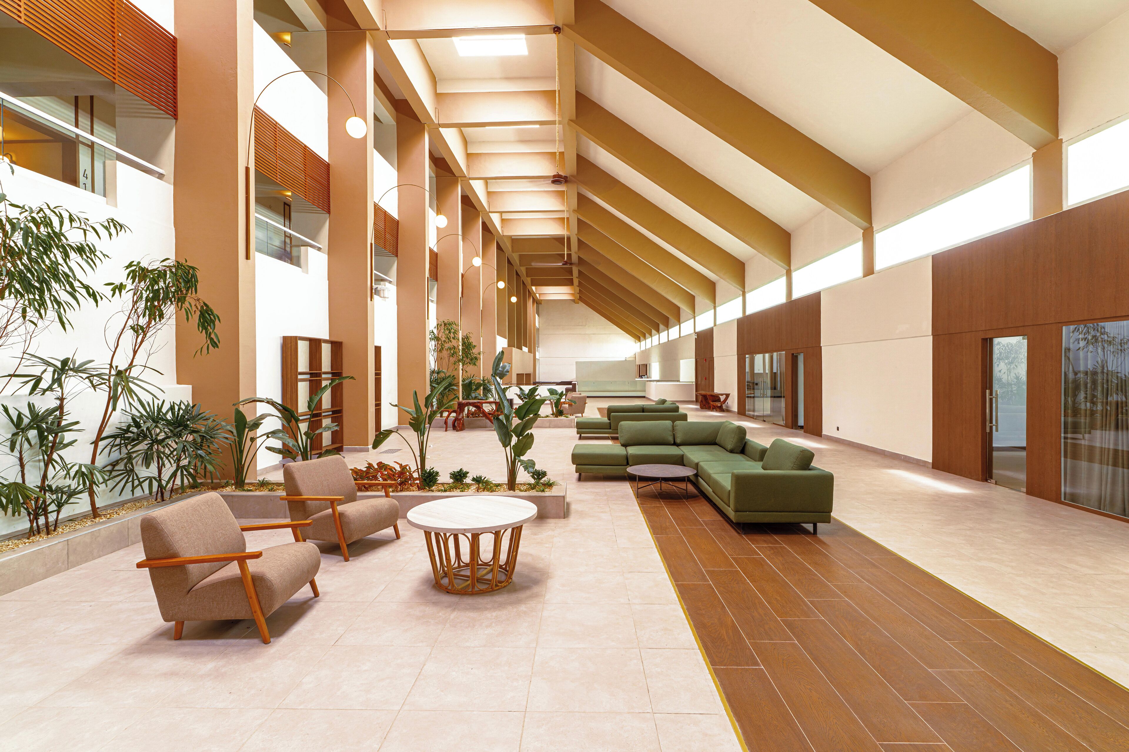A spacious lobby with seating areas, a central table, and large windows allowing natural light.