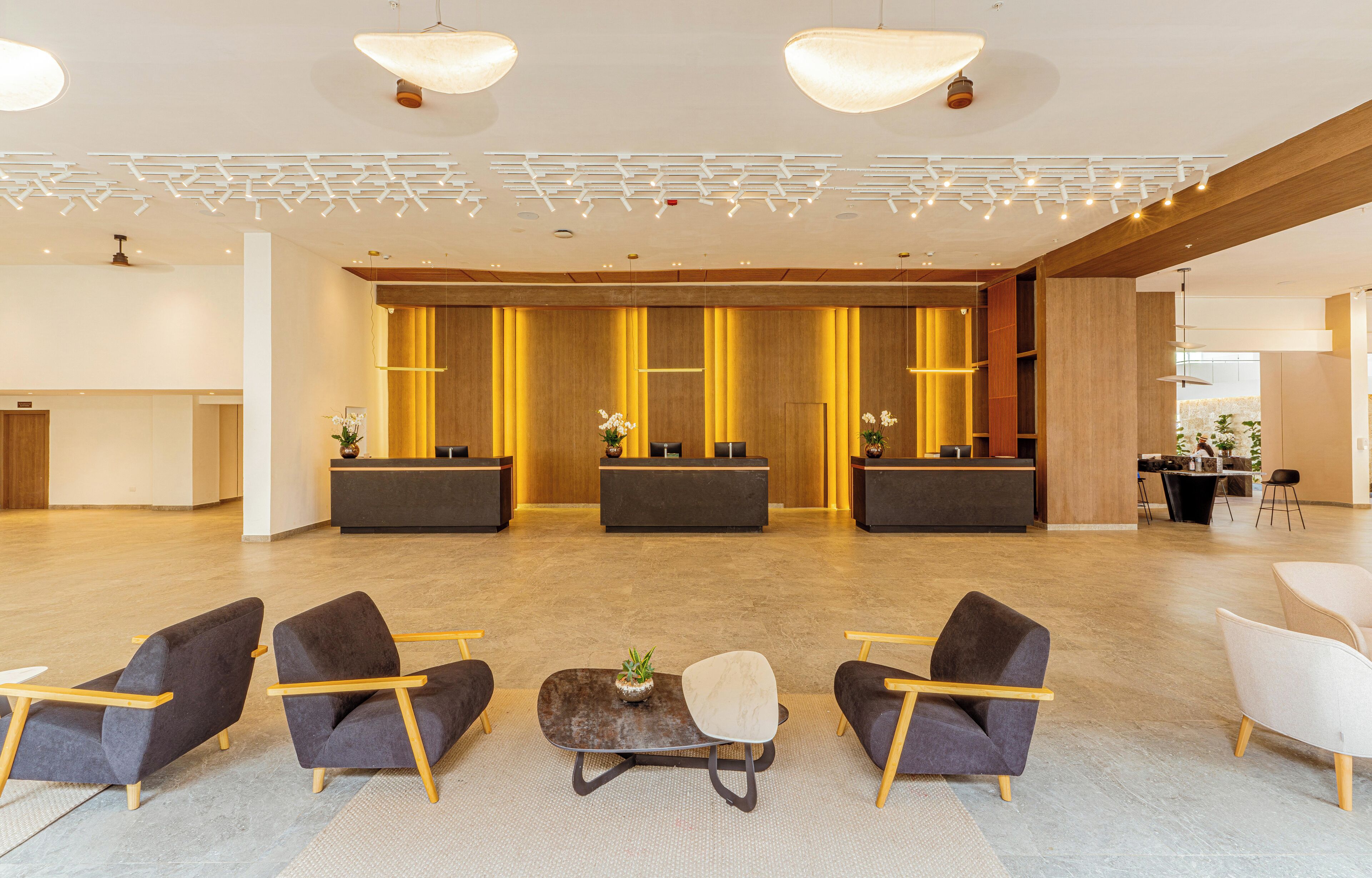 A spacious lobby with modern furniture, a reception desk, and a seating area.