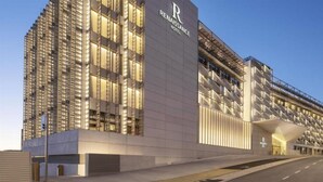 Un hotel moderno con un evidente cartello 'Renaissance Hotel', caratterizzato da una facciata elegante, ampie finestre e un ingresso distintivo.