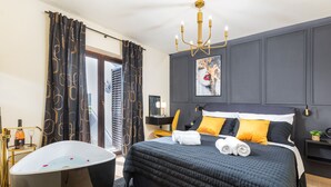 Ein modernes Schlafzimmer mit einem großen Bett, einer Badewanne und einer Kristallleuchter.