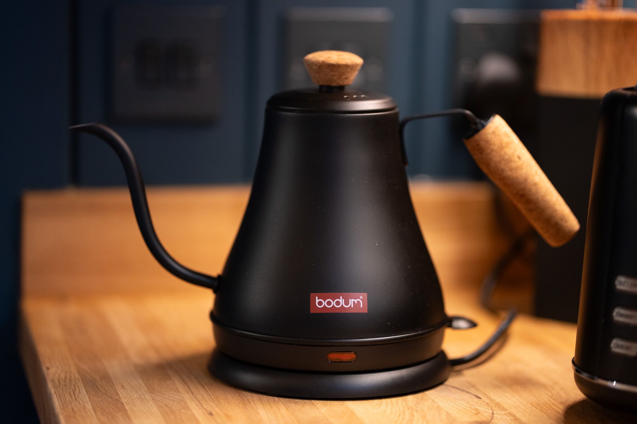 En sort Bodum kaffemaskine med et korkprop på et træbord.