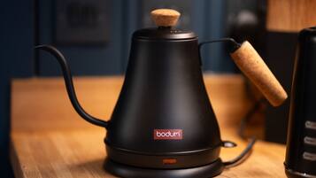 En sort Bodum kaffemaskine med et korkprop på et træbord.