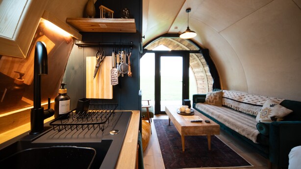 A cozy, compact living space with a kitchenette, a sofa, and a dining area.