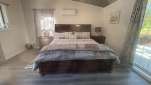 A bedroom with a bed, a wooden dresser, a window with curtains, and a small bedside table. - perfect studio, few minutes away to the heart of new Paltz & Mohonk Mountain (New Paltz)