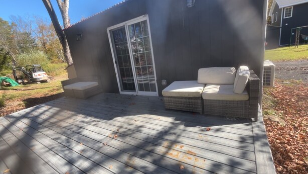 A house with a covered patio, a large window, and a small porch area.