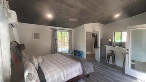A compact room with a bed, a small table, a chair, a window with a view, and a door. - perfect studio, few minutes away to the heart of new Paltz & Mohonk Mountain (New Paltz)