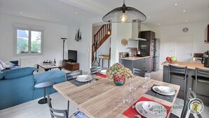 Un appartement moderne comprenant un coin repas, une cuisine, un salon et un escalier.