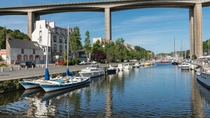 Un canal bordé de bateaux, un pont et des bâtiments le long de la rive.