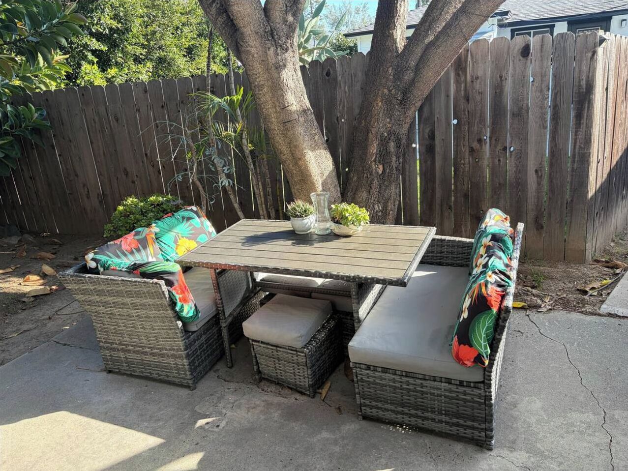 Shaded private patio with cozy wicker seating and tropical accents