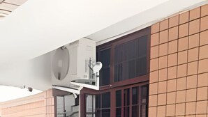 Un edificio con un amplio ventanal, un muro de azulejos y un techo plano.